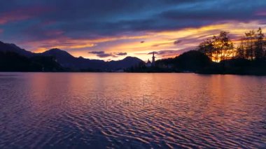 Slovenya, Bled Gölü 'ndeki Varsayım Kilisesi' nin günbatımı manzarası. Video.