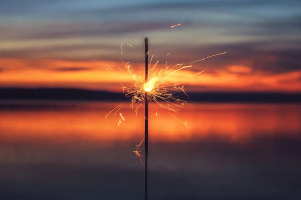 Luz de Bengala en el fondo de la puesta del sol, Año Nuevo con bengalas —  Fotos de Stock