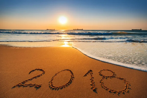 Feliz Año Nuevo 2018 concepto, letras en la playa. Salida del sol del mar — Foto de Stock