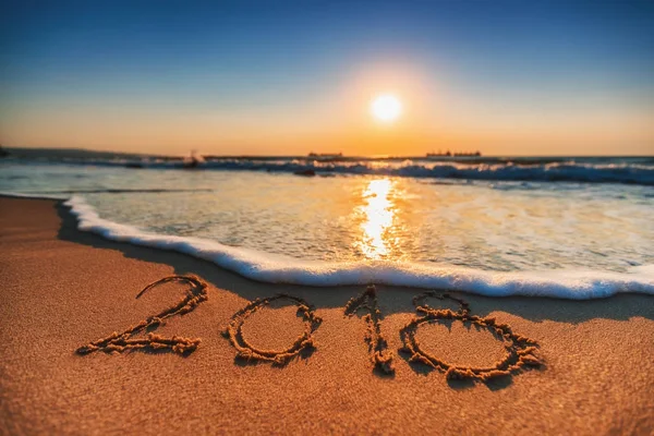 Ευτυχισμένο το νέο έτος 2018 έννοια, γράμματα στην παραλία. Ανατολή στη θάλασσα — Φωτογραφία Αρχείου