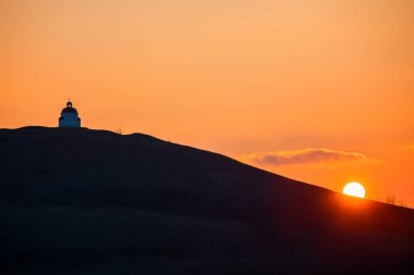 Dağ tepe batımında kiliseyle