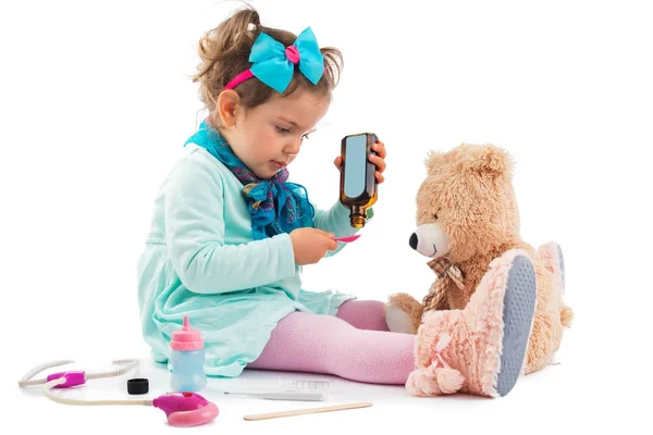 Cute kid girl playing doctor with plush toy at home — Stock Photo, Image