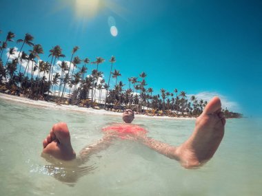 Man enjoying turquoise water of Caribbean sea and Punta Cana bea clipart