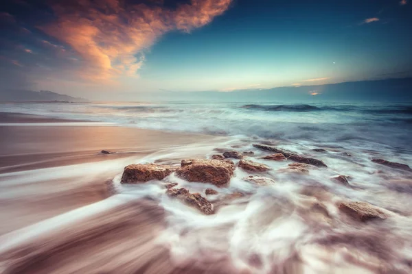 Zonsopgang boven het strand. Golven stenen wassen. — Stockfoto