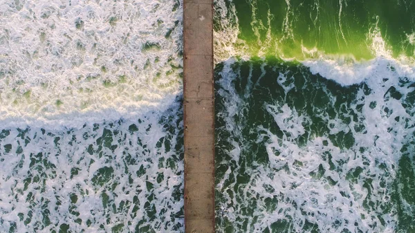 Vista aerea su grandi onde verdi del mare e vecchio ponte rotto — Foto Stock