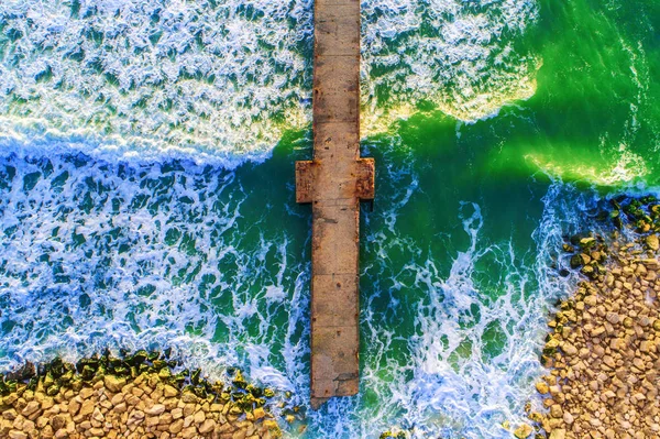 Luftaufnahme über die alte kaputte Brücke im Meer, Sonnenaufgangsaufnahme. — Stockfoto