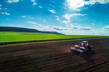 Aerial view of tractors working on the harvest field clipart