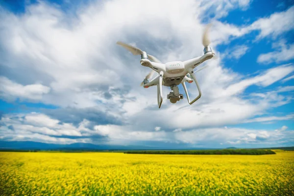 Quadricóptero de drones voadores sobre o campo de colza — Fotografia de Stock