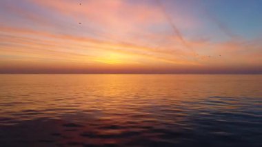 Hava ve deniz suyun altın gündoğumu görünümünü ve dalgalanma dalgalar