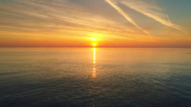 Hava ve deniz suyun altın gündoğumu görünümünü ve dalgalanma dalgalar