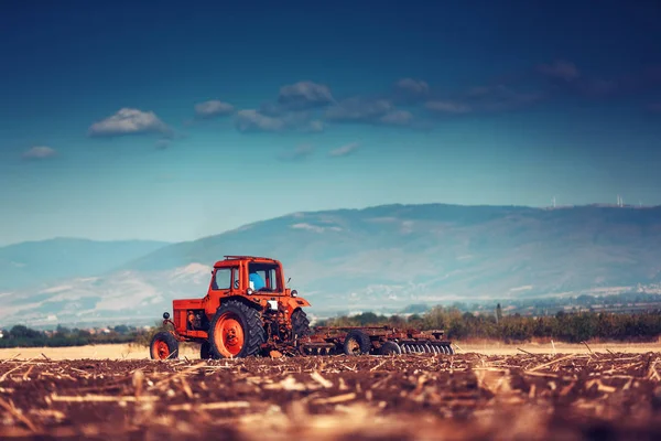 Jordbrukare i traktor förbereder mark med såbäddskultivator — Stockfoto