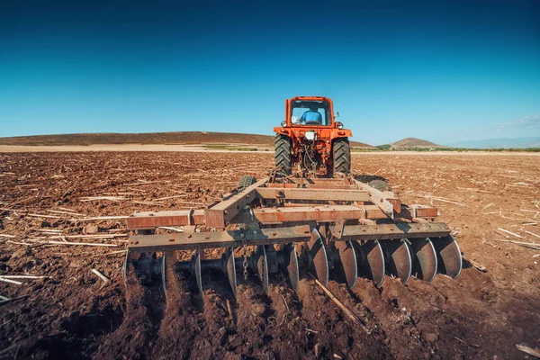 Agricultor en tractor preparando tierra con cultivador de semillero —  Fotos de Stock