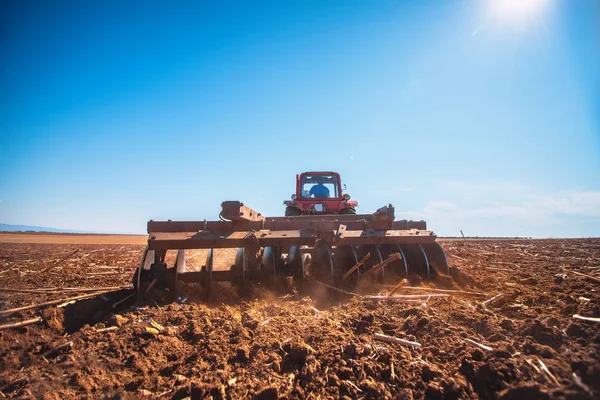 Agricultor en tractor preparando tierra con cultivador de semillero — Foto de Stock