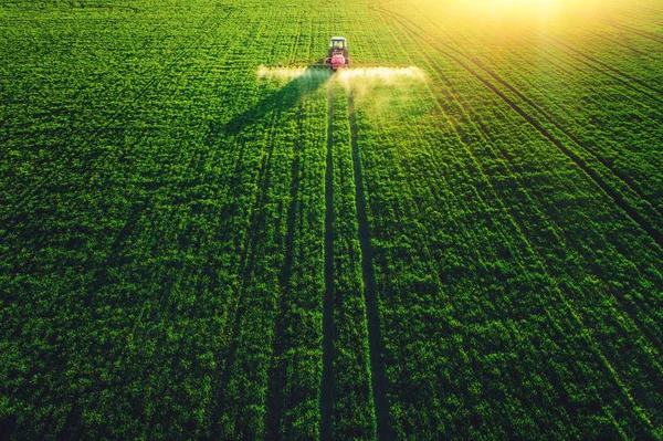 Luftaufnahme von Ackerschlepper pflügt und sprüht auf Feld — Stockfoto