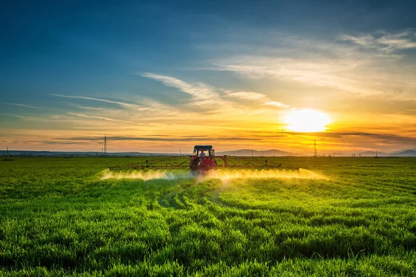 Tracteur agricole labourage et pulvérisation sur le terrain — Photo