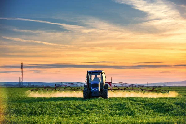 Сельскохозяйственное тракторное вспахивание и распыление на поле — стоковое фото