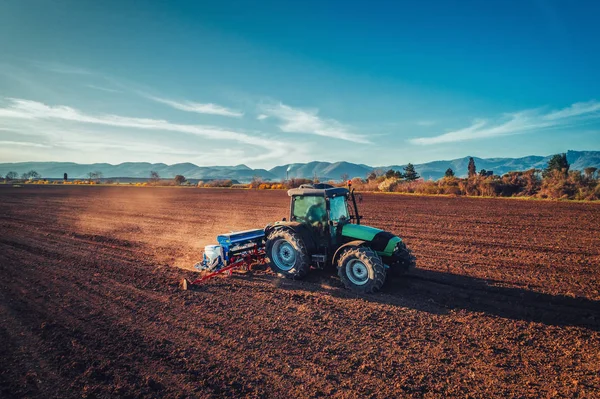 Landwirt mit Traktor sät Getreide auf Feld — Stockfoto