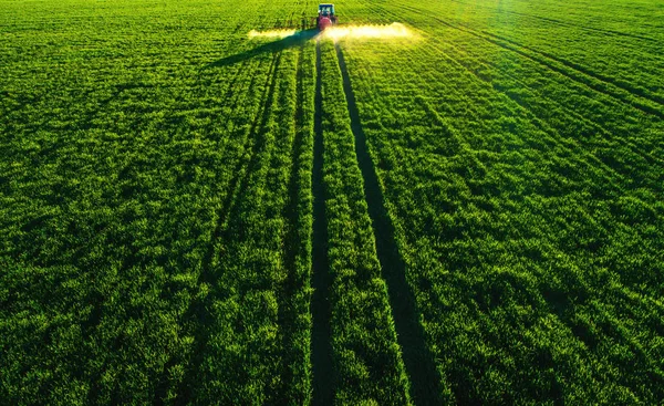 Luftaufnahme von Ackerschlepper pflügt und sprüht auf Feld — Stockfoto