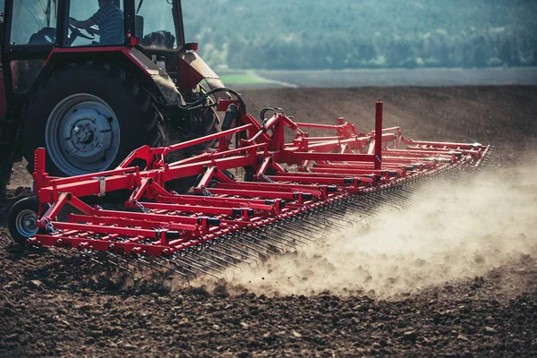 Agricultor com culturas de sementeira de tractores no campo — Fotografia de Stock