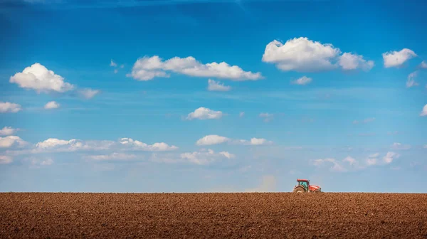 Agricultor com culturas de sementeira de tractores no campo — Fotografia de Stock
