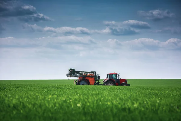 Plantação de tratores agrícolas e pulverização no campo — Fotografia de Stock