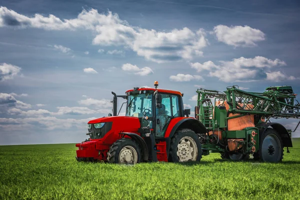 Сельскохозяйственное тракторное вспахивание и распыление на поле — стоковое фото
