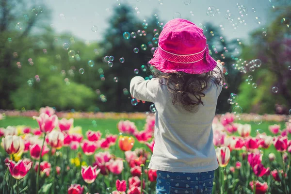 Küçük bir kız yaz parkta sabun köpüğü üfleme — Stok fotoğraf