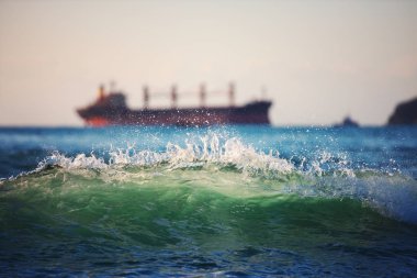 Yelkenli kargo gemisi ve gün doğumunda dalgalar. Ulaşım. Lojistik. Nakliye