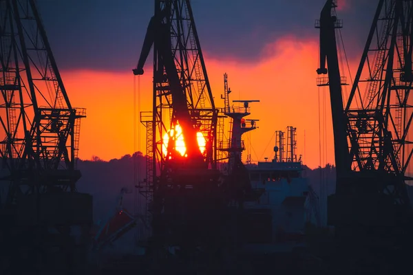 Pôr-do-sol colorido sobre o porto marítimo e guindastes industriais, Varna, Bulgária — Fotografia de Stock