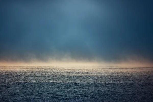 Nascer do sol do mar e manhã nebulosa. Nevoeiro acima da água ondulação azul, vista aérea — Fotografia de Stock