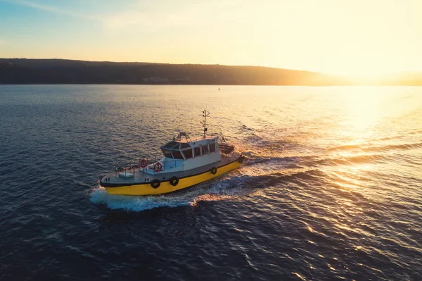 Parlak altın deniz suyuyla gün batımında yelken açan devriye botu — Stok fotoğraf