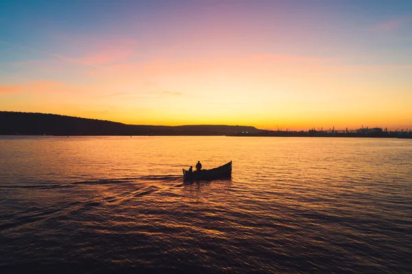 Coucher de soleil sur le bateau de pêche et l'eau de mer dorée brillant — Photo