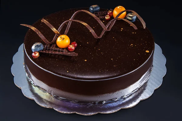 Chocoladetaart met decoratie en vruchten als achtergrond — Stockfoto