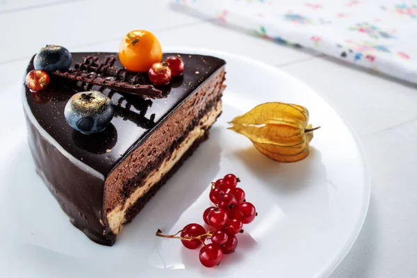 Chocoladetaart met decoratie en fruit op witte houten ondergrond — Stockfoto