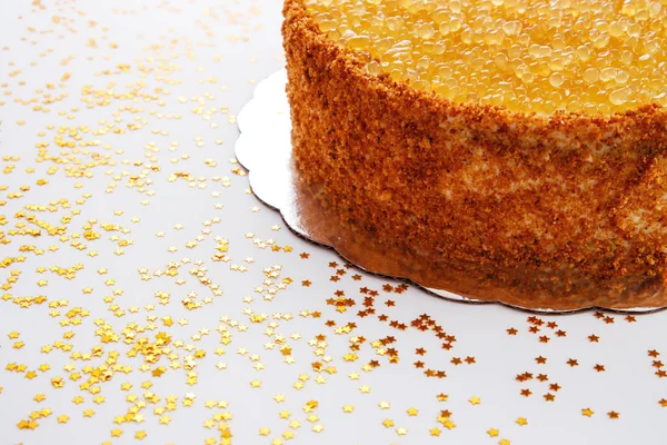 Torta di miele con perle dorate, noci e crema di latte isolata su sfondo bianco — Foto Stock