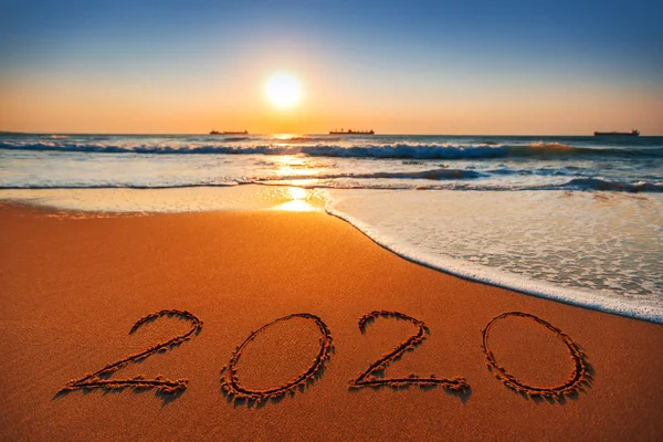 Frohes neues Jahr 2020 Konzept, Schriftzug am Strand. Sonnenaufgang am Meer — Stockfoto