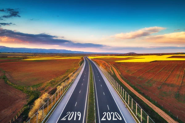 Veduta aerea dell'autostrada al tramonto. Sfondo di trasporto. Paesaggio con strada vicino a campi di campagna. — Foto Stock