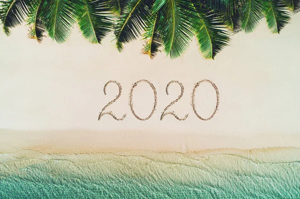 Feliz año nuevo concepto, 2020 escrito en la arena. Vacaciones verano — Foto de Stock