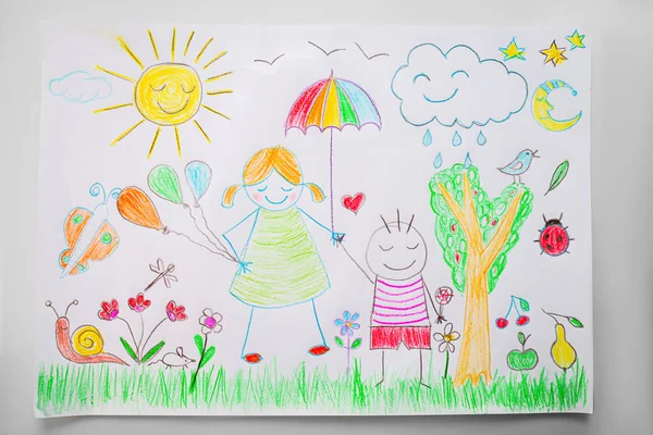 Çocuk renkli kalemlerle mutlu bir aile çiziyor. — Stok fotoğraf