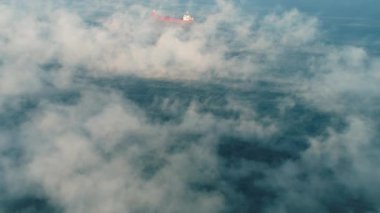 Kargo konteynır gemisinin hava görüntüsü, deniz sisi içinde yelkenler, teslimat konteynırları için çalışan vinç gemisi.
