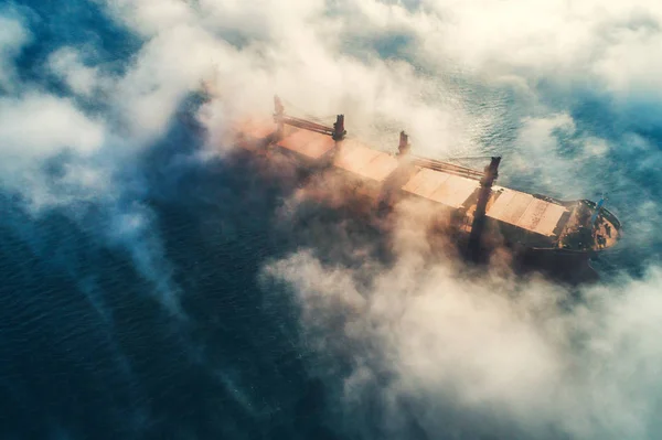 Φορτηγό πλοίο και σιλουέτες γερανών σε ομίχλη θαλάσσης, γερανοφόρο σκάφος που εργάζεται για την παράδοση εμπορευματοκιβωτίων παράδοσης — Φωτογραφία Αρχείου