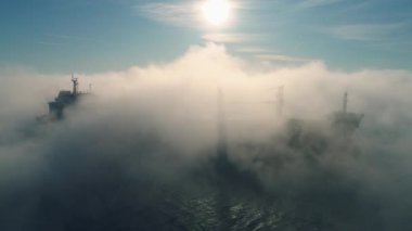 Kargo konteynır gemisinin hava görüntüsü, deniz sisi içinde yelkenler, teslimat konteynırları için çalışan vinç gemisi.