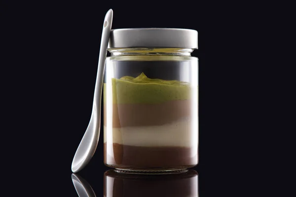 Melk romige dessert in pot met noten, chocolade en cacaobonen — Stockfoto