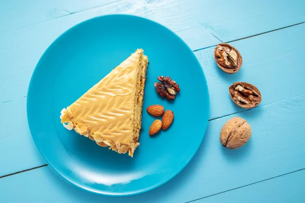 Cake with peanuts, walnuts, chocolate and caramel cream on blue — 스톡 사진