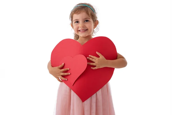 Feliz niña sostiene tarjetas en forma de corazón en sus manos. Sentir amor concepto — Foto de Stock