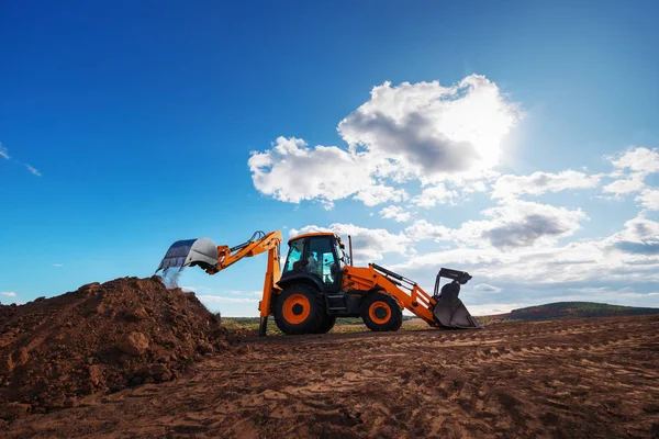 Wheel loader excavator with field background during earthmoving work, construction building — Stock Photo, Image