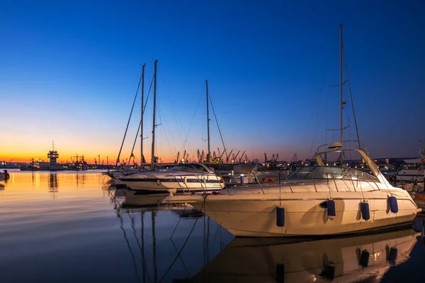 Puerto de yates y hermosa puesta de sol sobre Varna, Bulgaria. Puerto de velero, muchos hermosos yates de vela amarrados en el mar . — Foto de Stock