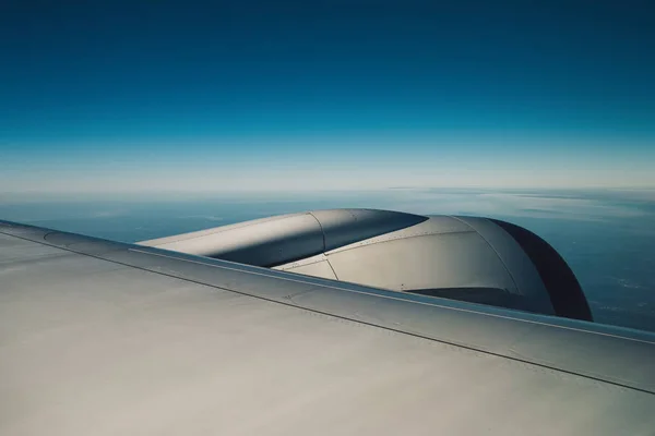 在天空上空飞行的飞机的机翼, 有云雾和城市拉 — 图库照片