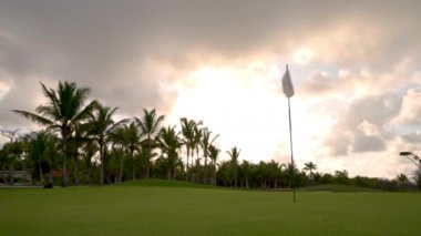 Lüks tropikal tatil köyündeki golf sahasında. Spor sahalarında, bahçelerde ve palmiyelerde gün batımı