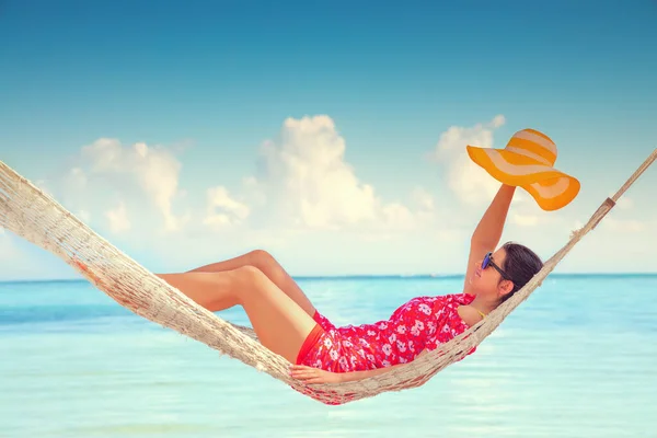 小女孩躺在高高的棕榈树下的吊床上 热带海滩 — 图库照片